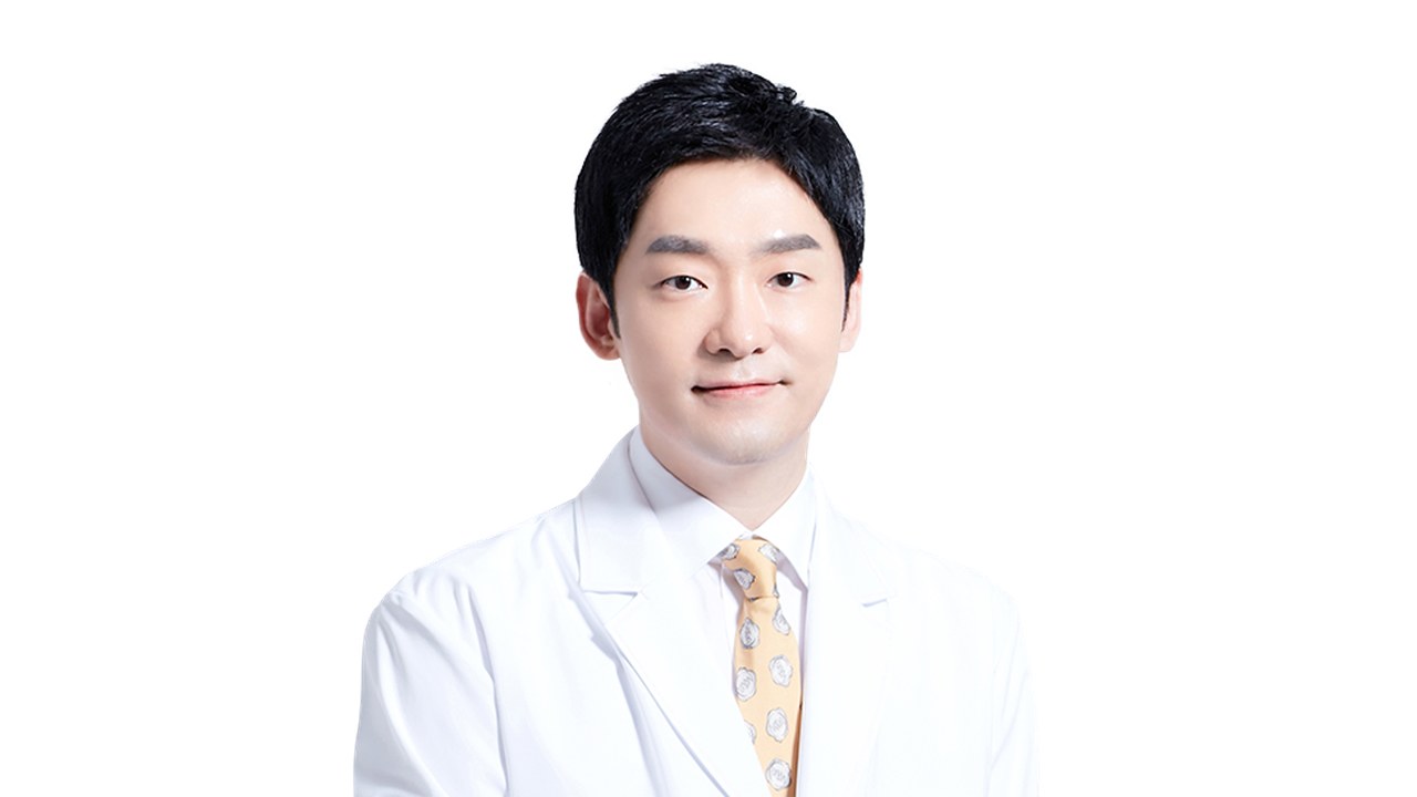흰 가운에 노란 무늬 넥타이를 맨 도언록 원장의 상반신 프로필 사진, 흰 배경